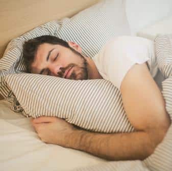 Man sleeping in bed to help him study more effectively